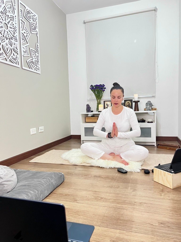 Patricia Olarte guiando una práctica virtual de Zenflow frente a sus computadores